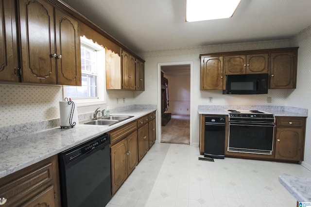 kitchen featuring sink, black appliances, and dark brown cabinets