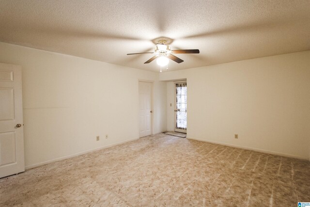 carpeted spare room featuring ceiling fan and a textured ceiling