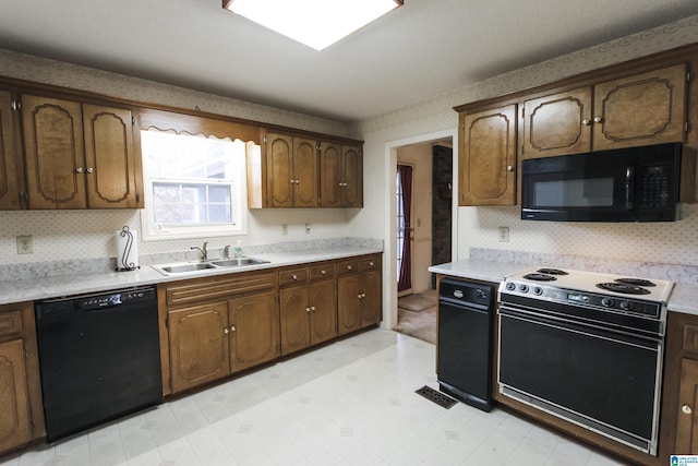 kitchen with black appliances, backsplash, and sink