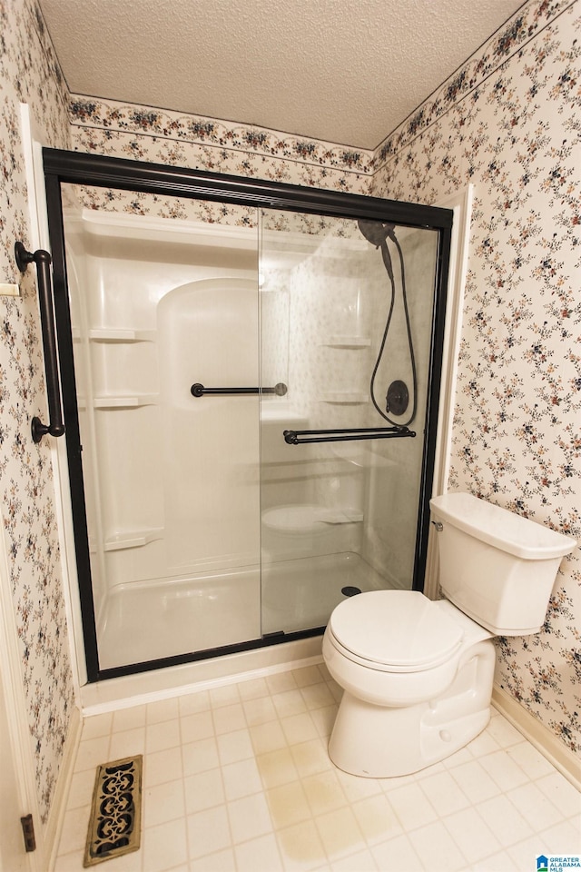 bathroom with tile patterned floors, a shower with shower door, a textured ceiling, and toilet