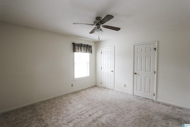 unfurnished room with a textured ceiling, light colored carpet, and ceiling fan