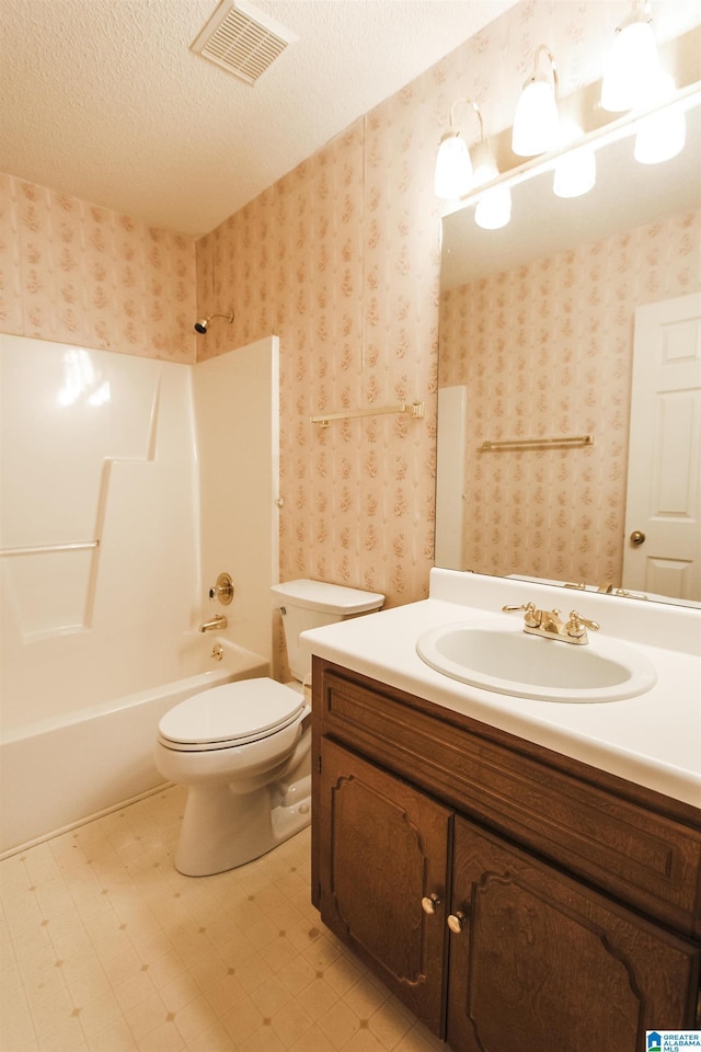 full bathroom featuring vanity, a textured ceiling, shower / bath combination, and toilet