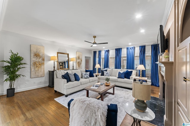 living room featuring ceiling fan, ornamental molding, and hardwood / wood-style flooring