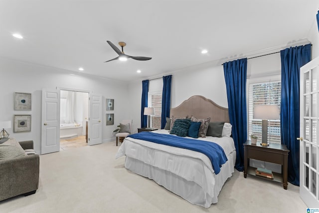 carpeted bedroom featuring ensuite bath, ceiling fan, and crown molding