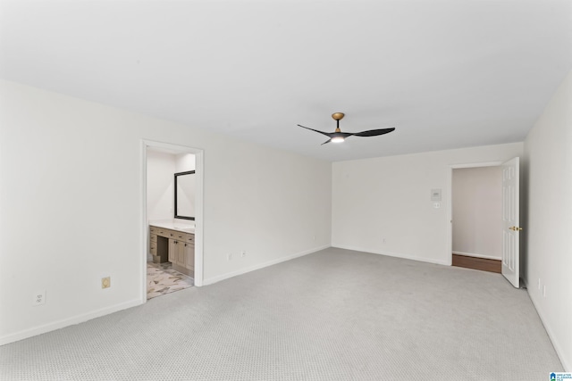 empty room featuring ceiling fan and light colored carpet