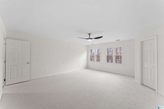 spare room featuring light colored carpet and ceiling fan