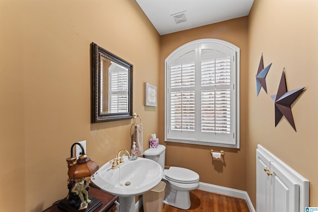 bathroom with toilet, sink, and hardwood / wood-style flooring