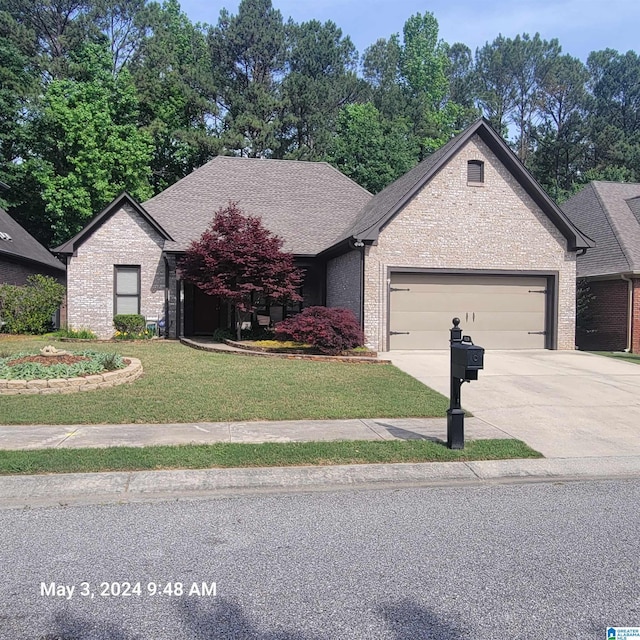 view of front of house with driveway, brick siding, roof with shingles, and an attached garage