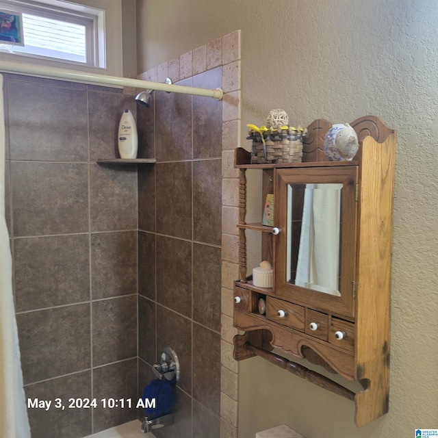 bathroom with a textured wall and shower / tub combination