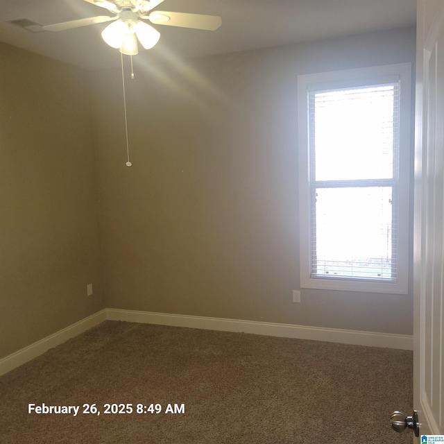 empty room with ceiling fan, dark carpet, and baseboards