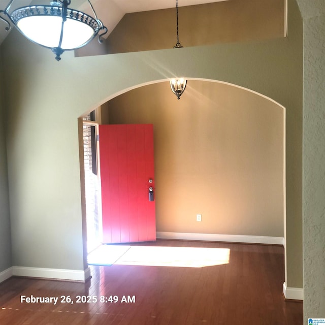 foyer entrance featuring vaulted ceiling, wood finished floors, and baseboards