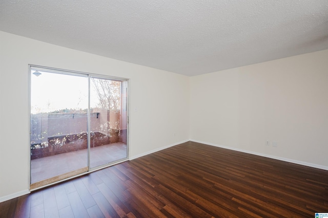 unfurnished room with dark hardwood / wood-style flooring and a textured ceiling