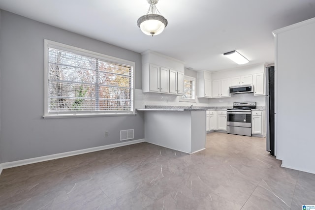 kitchen featuring light stone countertops, appliances with stainless steel finishes, a kitchen bar, kitchen peninsula, and white cabinetry