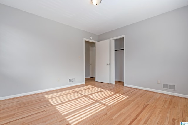 unfurnished bedroom with light wood-type flooring and a closet