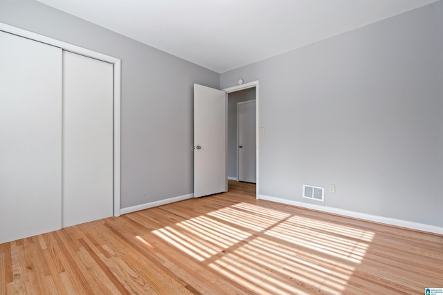 unfurnished bedroom featuring a closet and hardwood / wood-style floors