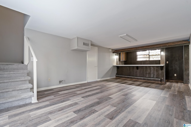 basement with wood-type flooring and wooden walls