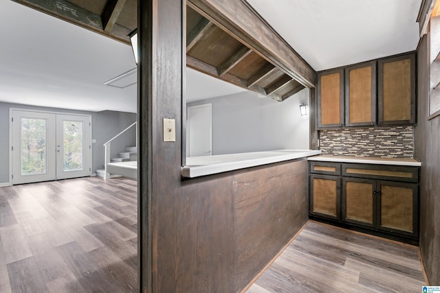 kitchen featuring beam ceiling, backsplash, french doors, and light hardwood / wood-style floors