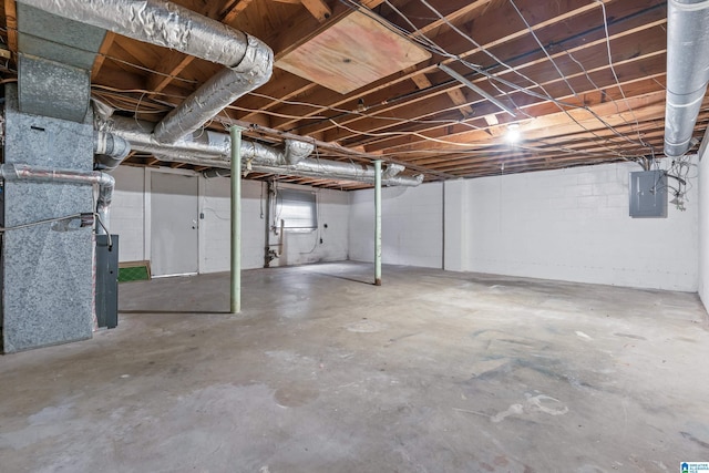 basement featuring electric panel and heating unit