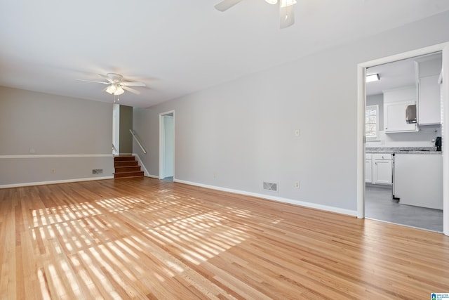 unfurnished living room with light wood-type flooring and ceiling fan