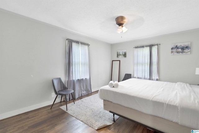 bedroom featuring dark hardwood / wood-style floors, ceiling fan, and a textured ceiling