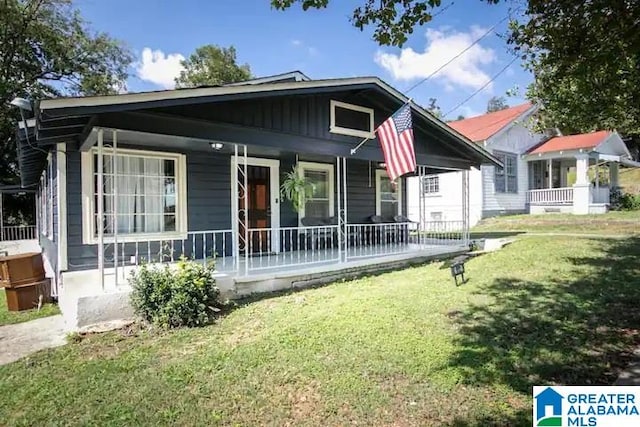 rear view of property with a porch and a yard