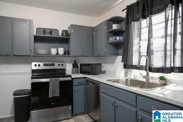 kitchen with appliances with stainless steel finishes, backsplash, a healthy amount of sunlight, and sink