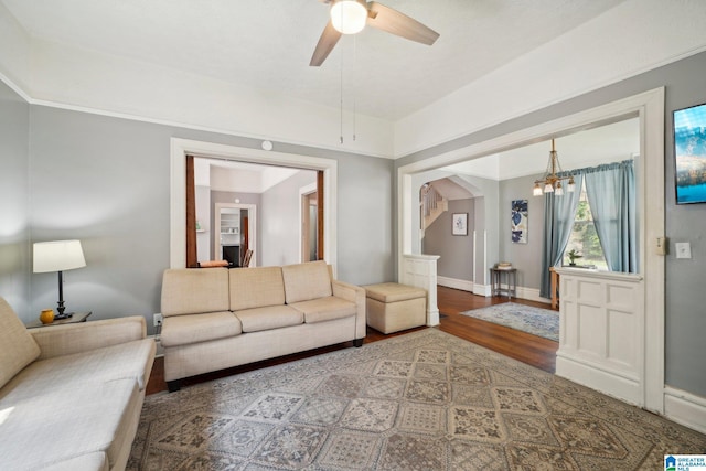 living room featuring ceiling fan with notable chandelier and hardwood / wood-style flooring