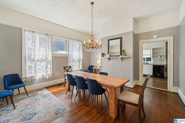 dining space featuring a chandelier, wood-type flooring, and a textured ceiling