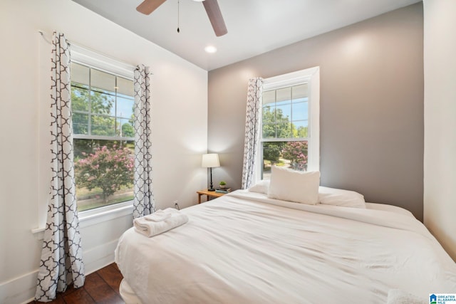 bedroom featuring dark hardwood / wood-style floors, multiple windows, and ceiling fan