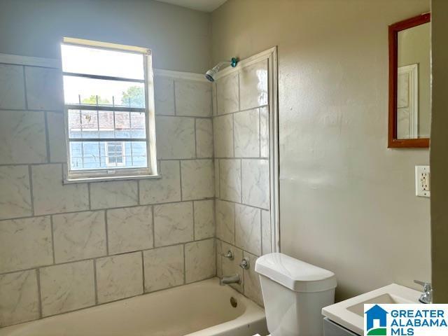 full bathroom with vanity, tiled shower / bath combo, and toilet