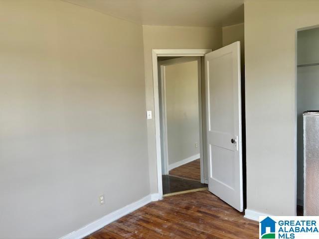 unfurnished bedroom with dark hardwood / wood-style floors