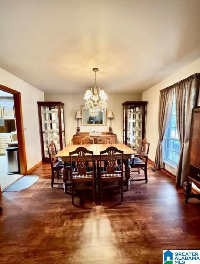 dining room with dark hardwood / wood-style floors and a notable chandelier