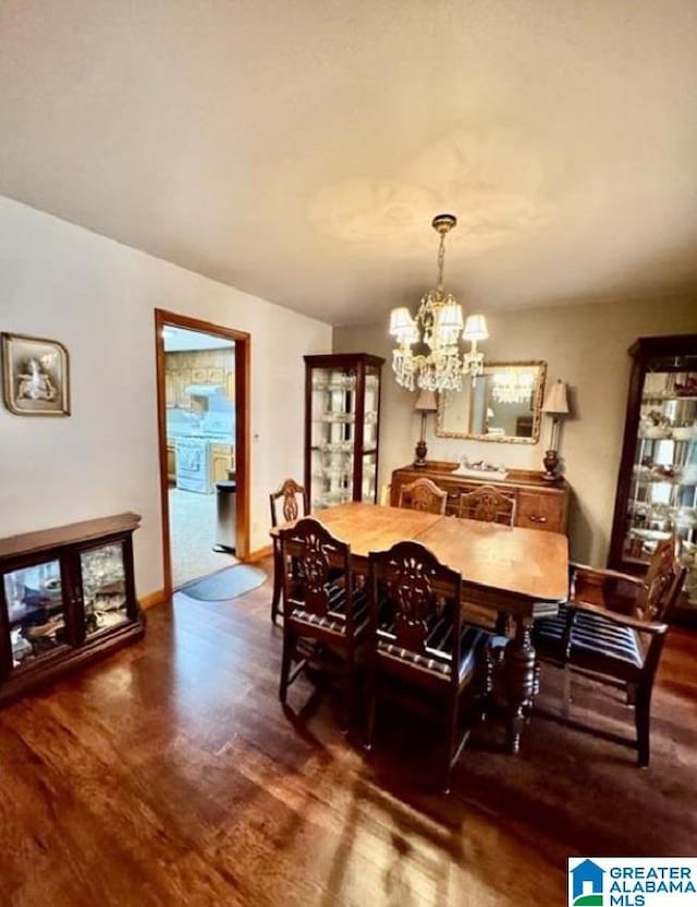 dining space with dark hardwood / wood-style flooring and a chandelier