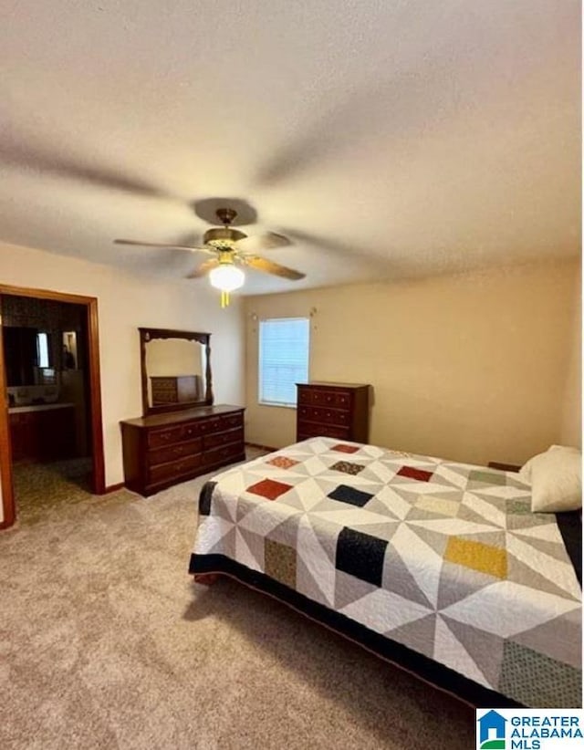 bedroom featuring ceiling fan, light colored carpet, and a textured ceiling