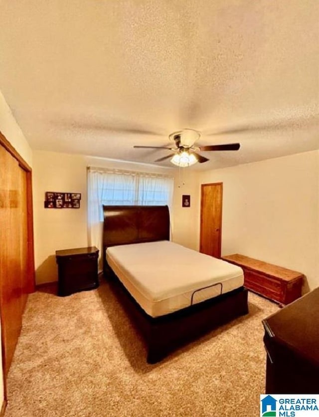 bedroom featuring ceiling fan, carpet floors, a textured ceiling, and a closet