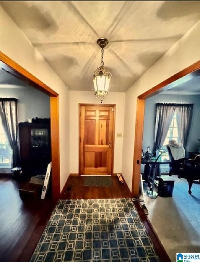 foyer with a chandelier and dark hardwood / wood-style floors