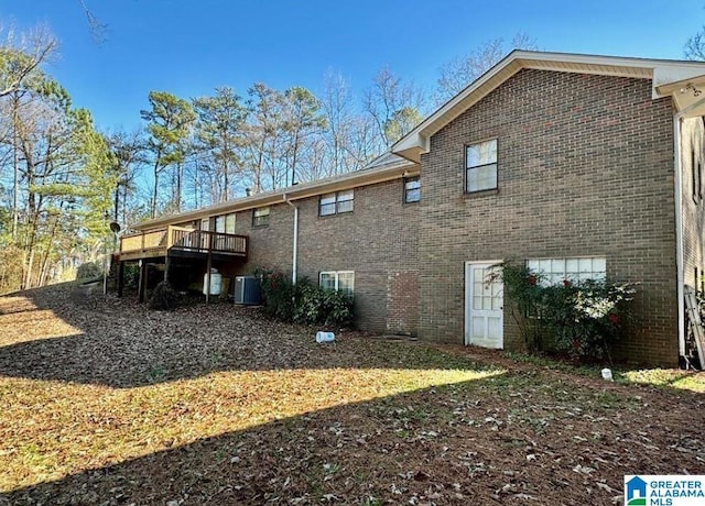 rear view of property with a wooden deck and central AC unit