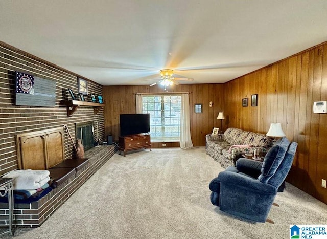 carpeted living room featuring a fireplace, ceiling fan, and wooden walls