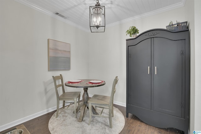 dining area with dark hardwood / wood-style flooring, a chandelier, and ornamental molding