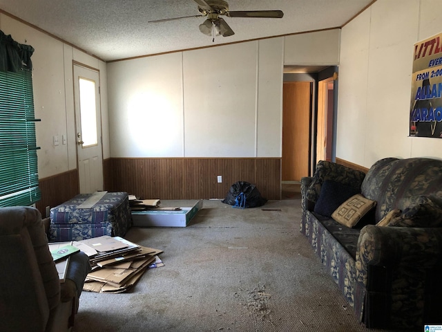 living room with carpet, a textured ceiling, ceiling fan, and crown molding