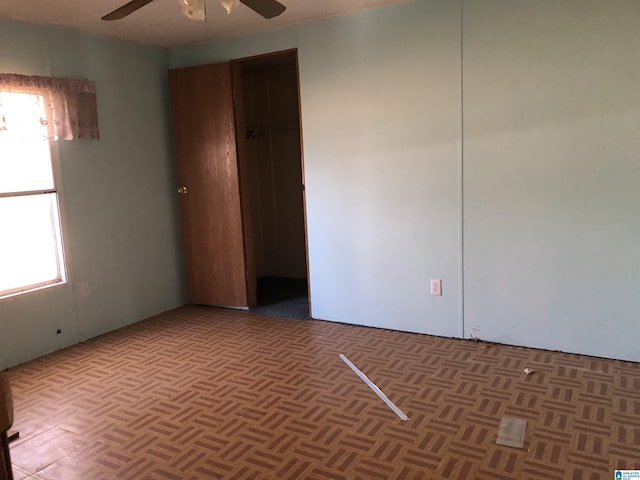 unfurnished room with dark parquet floors and ceiling fan