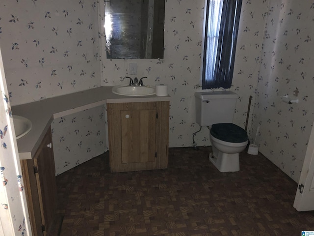 bathroom featuring vanity, toilet, and parquet flooring