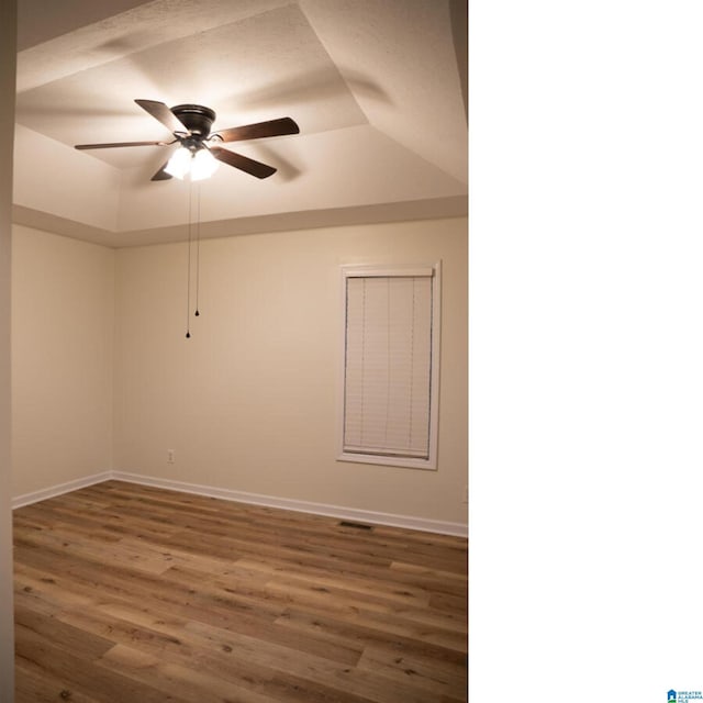 spare room with ceiling fan, dark wood-type flooring, and vaulted ceiling