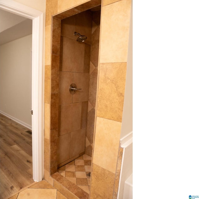 bathroom with hardwood / wood-style floors and tiled shower