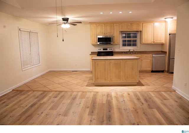 kitchen featuring ceiling fan, sink, light brown cabinetry, light tile patterned flooring, and appliances with stainless steel finishes