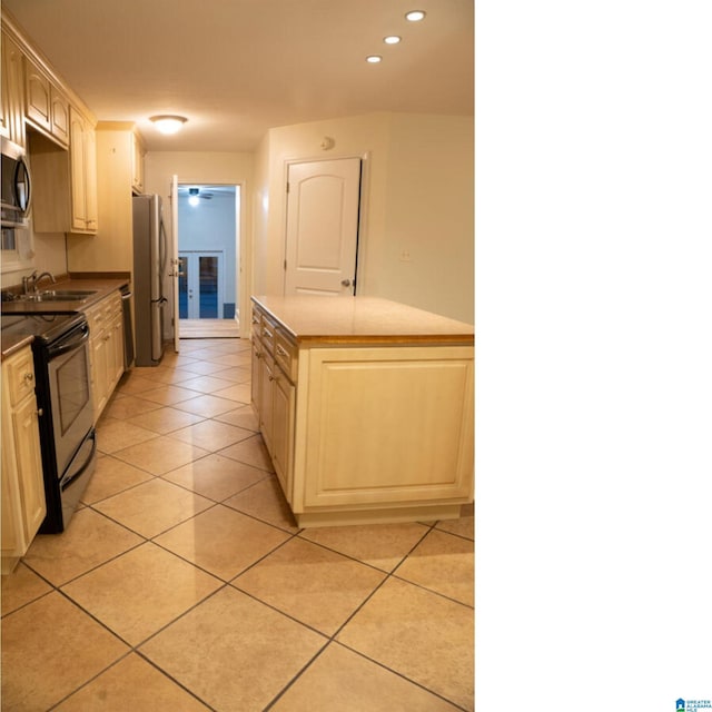 kitchen with light tile patterned floors, sink, and appliances with stainless steel finishes