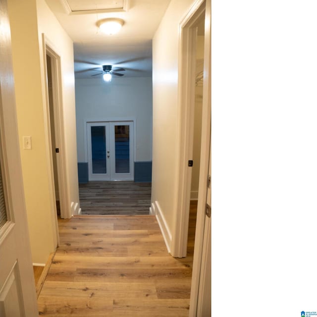 hallway featuring french doors and light hardwood / wood-style flooring