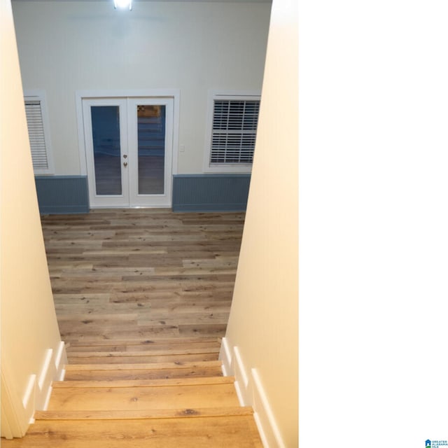 stairway featuring hardwood / wood-style flooring and french doors