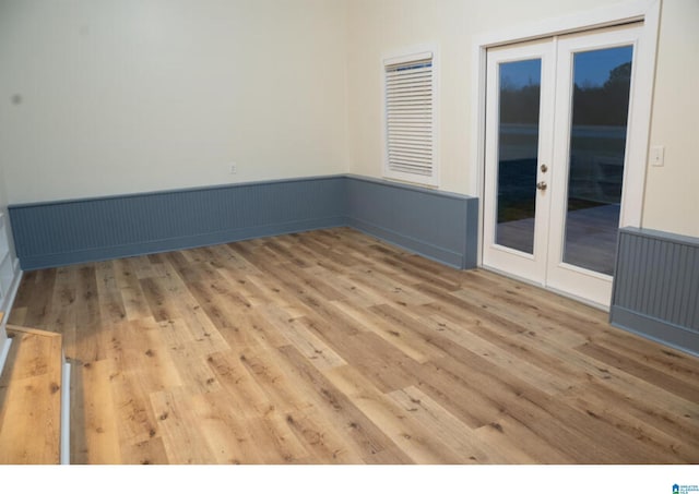 empty room with french doors and hardwood / wood-style flooring