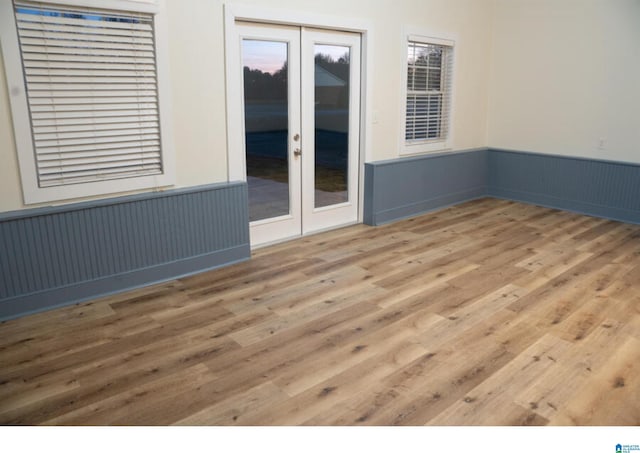 empty room with hardwood / wood-style floors and french doors